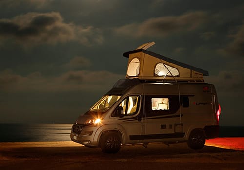 Class B van parked on a road at night